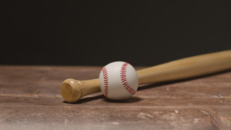 Close-Up-Studio-Baseball-Still-Life-With-Wooden-Bat-And-Ball-On-Wooden-Floor